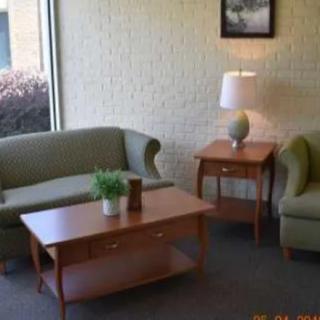 A cozy living room setup featuring a sofa, armchair, coffee table, and lamp.