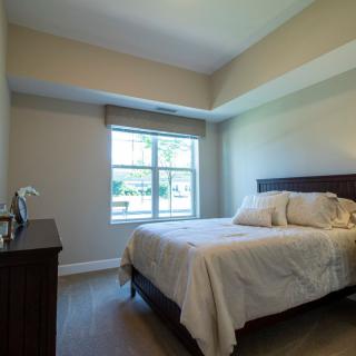A simple and minimalist bedroom with a bed by the window.
