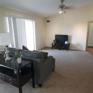 A spacious living room with a cozy sofa, television, and minimalistic decor.