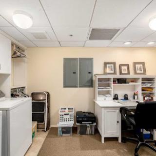 A neatly organized home office space featuring a desk and laundry area.