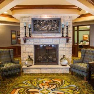 A welcoming lobby featuring a stone fireplace, comfortable seating, and vibrant decor.