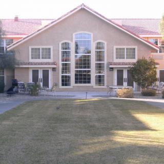 A large residential building with a well-maintained lawn and symmetrical windows.