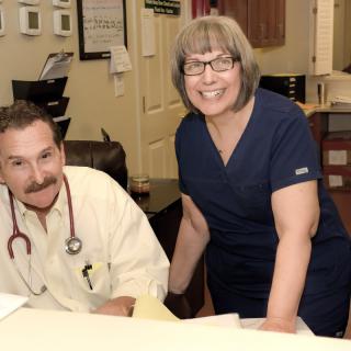 A doctor and a nurse working together in a healthcare office.