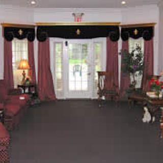 A well-decorated living room with large windows and elegant curtains.