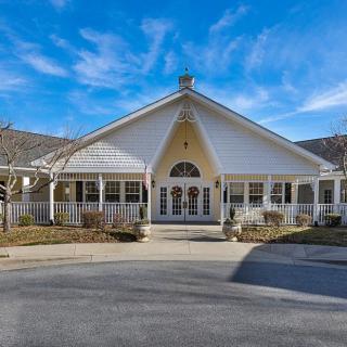 A residential building with a large front porch and a clear blue sky.
