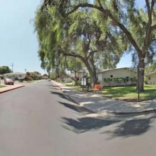 A quiet suburban street lined with trees and houses.