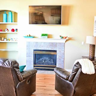 Cozy living room with a fireplace, TV, and comfortable armchairs.