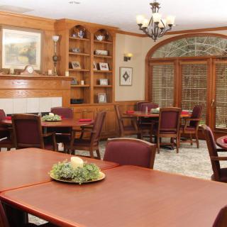 A cozy dining room with wooden furnishings and a chandelier.