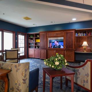 A cozy living room with a television, bookshelves, and comfortable seating.