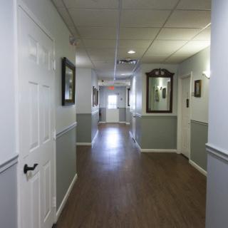 A quiet hallway with framed art on the walls and doors leading to rooms.