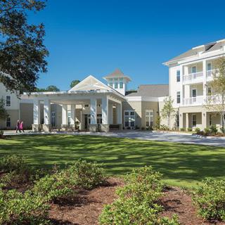A residential building with a well-maintained landscape under a clear blue sky.