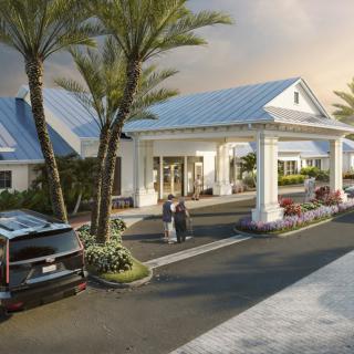 A welcoming entrance to a resort with palm trees and parked cars.