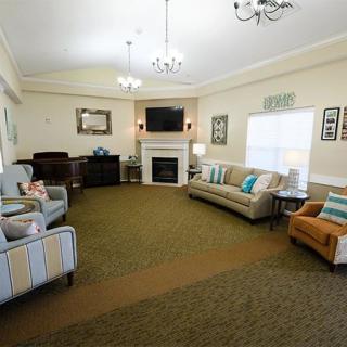 A cozy living room with sofas, chairs, a fireplace, and a television.