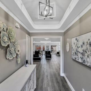 A modern hallway with stylish decor and artwork, featuring a contemporary lighting fixture.