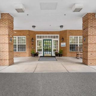 A brick building entrance with columns and large windows.