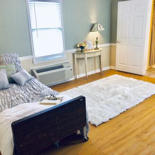 A cozy bedroom with a bed, fluffy rug, and elegant decor.