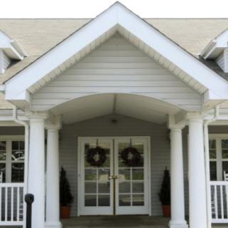 Front entrance of a house with columns and double doors.