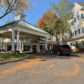 A welcoming entrance to a residential building, framed by vibrant autumn foliage.