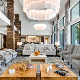 A modern and luxurious living room with elegant furniture and large windows.
