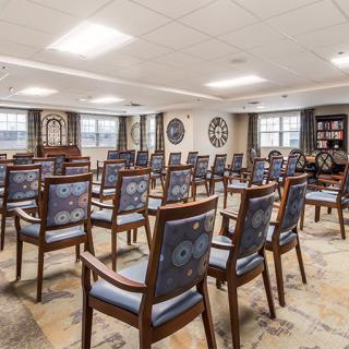 A well-arranged conference room with multiple rows of chairs facing the front.