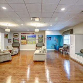 A spacious and elegantly decorated living room featuring comfortable seating and diverse artwork on the walls.