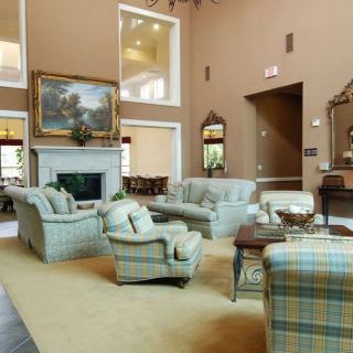 A spacious living room with soft blue seating and elegant decor.
