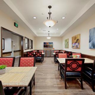 A modern dining area with tables and chairs, decorated with artwork on the walls.