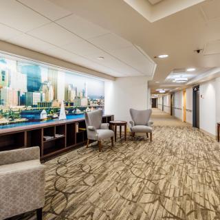 A modern hotel corridor with comfortable seating and artwork on the wall.