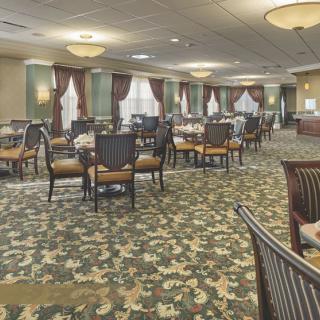 A spacious and elegantly decorated dining room with neatly arranged tables and chairs.