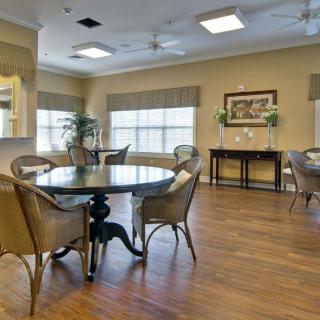 A bright and inviting dining area with a round table, chairs, and wooden flooring.
