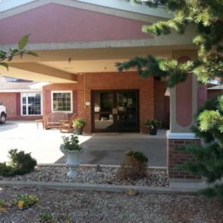 Entrance of a building with landscaping and seating area.