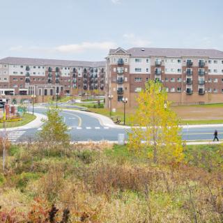 A view of a modern residential complex surrounded by green spaces and pathways.