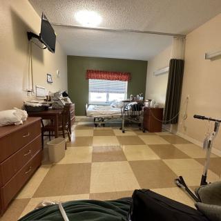 A hospital room with a patient bed and medical equipment.
