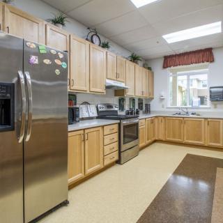 A spacious modern kitchen with wooden cabinets and stainless steel appliances.