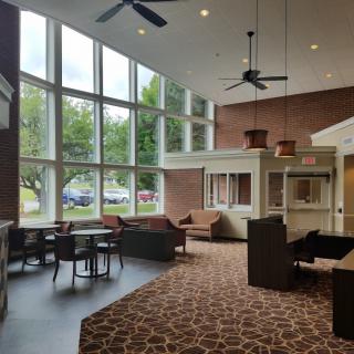 A modern lobby area with large windows and comfortable seating.