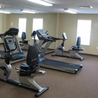 A gym room with exercise equipment including treadmills and stationary bikes.