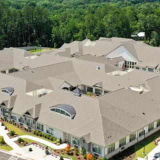 Aerial view of a large building complex surrounded by greenery.
