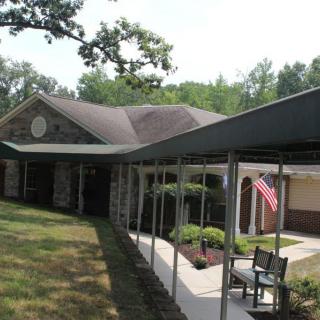 A suburban house with a covered pathway and a garden area, featuring an American flag.