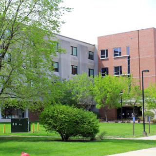 A view of a modern building surrounded by lush greenery.