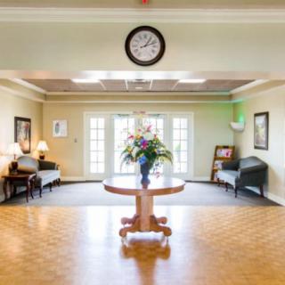 A bright and inviting lobby with a central table adorned with flowers, surrounded by sofas and decorative elements.