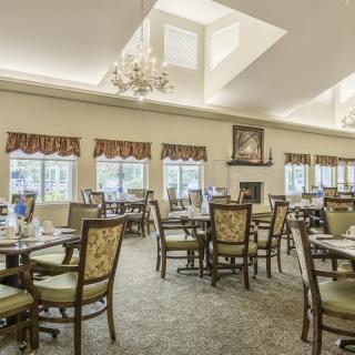A spacious dining area with elegant furniture and a chandelier.