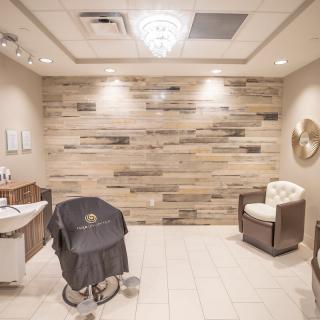 A modern and cozy hair salon interior featuring wood paneling and stylish furnishings.