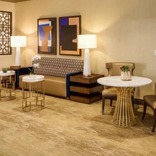 A modern lounge area featuring a comfortable sofa, stylish tables, and elegant lighting.