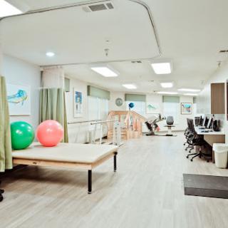 A spacious physical therapy room equipped with exercise balls and rehabilitation equipment.