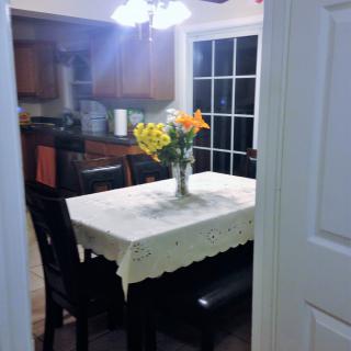 A cozy kitchen with a dining table adorned with a vase of flowers.