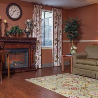 A cozy living room with warm tones featuring a fireplace, sofa, and decorative elements.