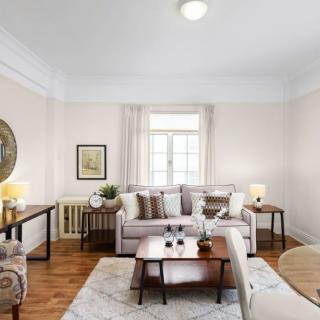 A cozy and elegantly decorated living room with a comfortable sofa, coffee table, and soft lighting.