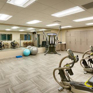 A modern gym with exercise equipment and large mirrors.