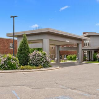 The welcoming entrance of a modern hotel, surrounded by well-maintained landscaping.