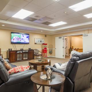 A cozy lounge area featuring recliner chairs and a wall-mounted television.